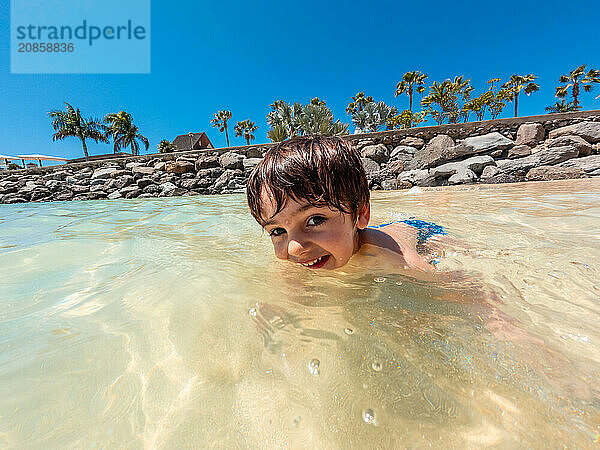 Portrait of a boy on vacation on a beach in the Canary Islands. Concept of happy family outdoors. Family vacation on the sea coast