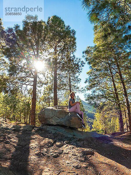 A woman sitting on a stone while hiking to Roque Nublo in Gran Canaria  Canary Islands