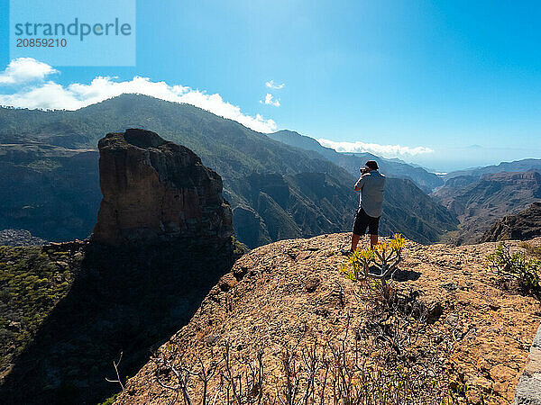 A photographer at the Roque Palmes viewpoint near Roque Nublo in Gran Canaria  Canary Islands