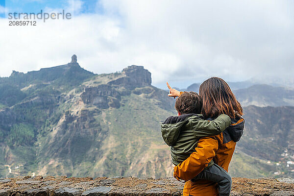 A mother with her son looking at Roque Nublo from a viewpoint. Gran Canaria  Spain  Europe