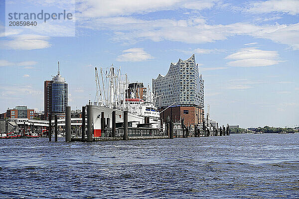 Hamburg harbour view with ships and clock tower by day  Hamburg  Elbe Philharmonic Hall in the Hafencity  Hanseatic City of Hamburg  Wide view over the Hamburg harbour with the Elbe Philharmonic Hall and ships under scattered clouds  Hanseatic City of Hamburg  Hamburg  Germany  Europe