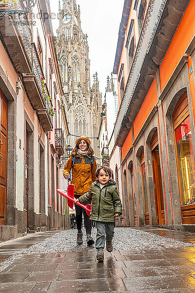 A mother playing with her son on a street near the Church of San Juan Bautista  Arucas Cathedral  Gran Canaria  Spain  Europe