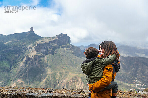 A mother with her son looking at Roque Nublo from a viewpoint. Gran Canaria  Spain  Europe