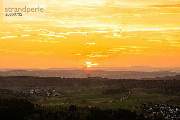 Panorama of a romantic landscape at sunset in the evening light. beautiful spring landscape in the mountains. Lawn and rolling hills. View from a cliff to the horizon. The Great Peak  Hesse  Germany  Europe