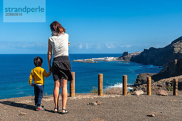 A mother and her son looking at Agaete from the Barraco de Guayedra viewpoint. Gran Canaria. Spain