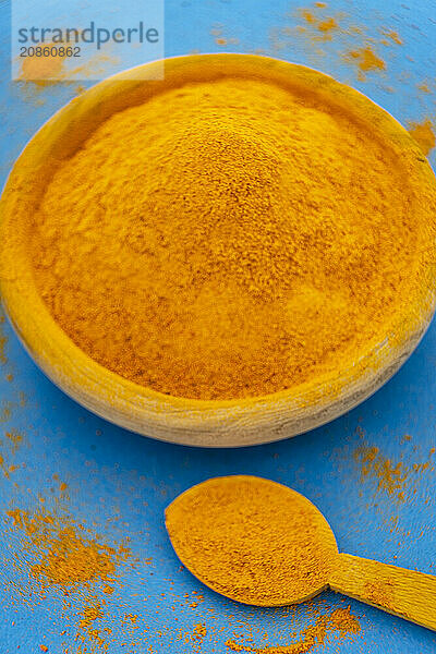 Ground turmeric on blue background