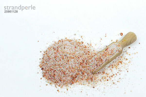 Top view of a wooden spoon with pink Himalayan salt isolated on white background and copy space