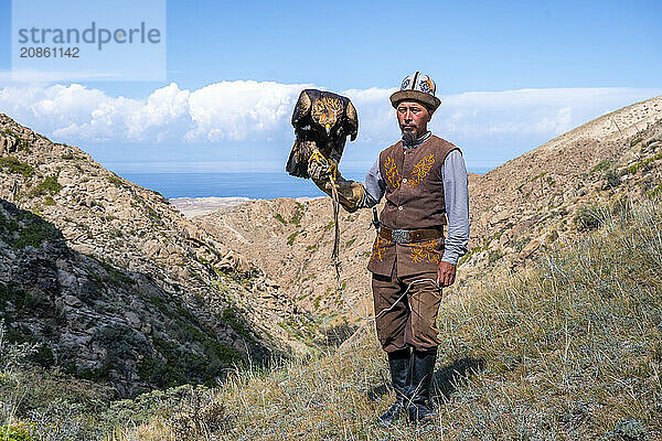 Traditional Kyrgyz eagle hunter with eagle in the mountains  hunting  near Bokonbayevo  Issyk Kul region  Kyrgyzstan  Asia