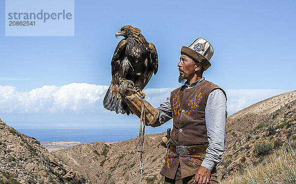 Traditional Kyrgyz eagle hunter with eagle in the mountains  hunting  near Bokonbayevo  Issyk Kul region  Kyrgyzstan  Asia