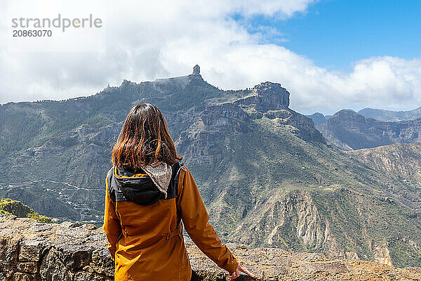 A tourist woman looking at Roque Nublo from a viewpoint on the mountain. Gran Canaria  Spain  Europe