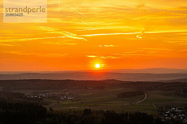 Panorama of a romantic landscape at sunset in the evening light. beautiful spring landscape in the mountains. Lawn and rolling hills. View from a cliff to the horizon. The Great Peak  Hesse  Germany  Europe