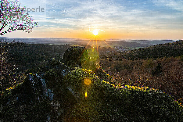 Panorama of a romantic landscape at sunset in the evening light. beautiful spring landscape in the mountains. Lawn and rolling hills. View from a cliff to the horizon. The Great Peak  Hesse  Germany  Europe