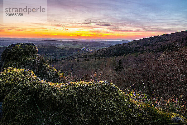 Panorama of a romantic landscape at sunset in the evening light. beautiful spring landscape in the mountains. Lawn and rolling hills. View from a cliff to the horizon. The Great Peak  Hesse  Germany  Europe