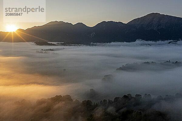 Aerial view  fog in front of mountains  sunrise  backlight  summer  view of Kochler mountains with Jochberg  Alpine foothills  Bavaria  Germany  Europe