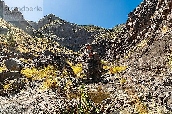 A hiker on the river on the climb to Charco Azul in the Podemos to Agaete in Gran Canaria  Canary Islands