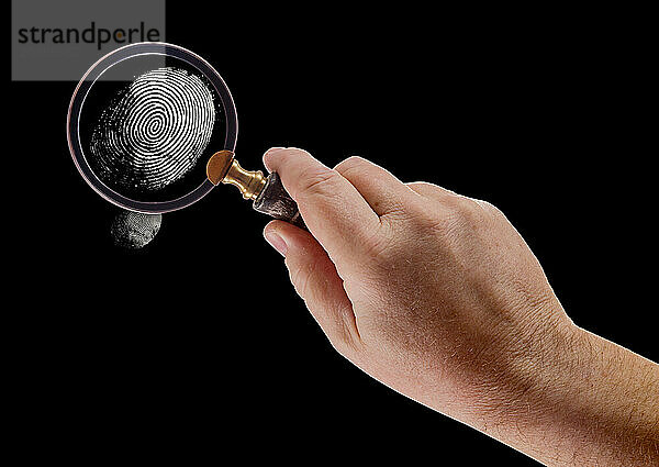 Male hand holding magnifying glass viewing A fingerprint on a black background