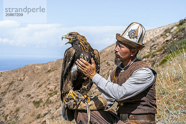 Traditional Kyrgyz eagle hunter with eagle in the mountains  hunting  near Bokonbayevo  Issyk Kul region  Kyrgyzstan  Asia