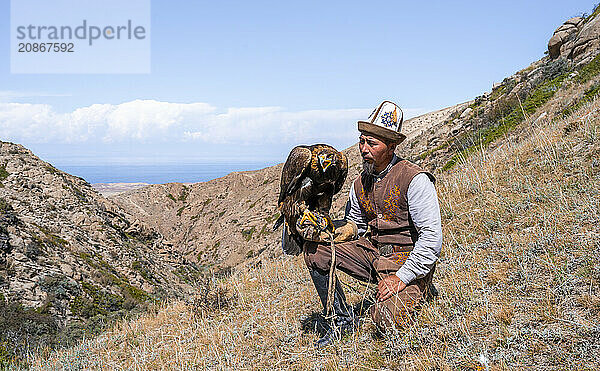 Traditional Kyrgyz eagle hunter with eagle in the mountains  hunting  near Bokonbayevo  Issyk Kul region  Kyrgyzstan  Asia