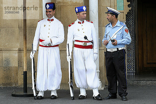 Guards at the Royal Palace in Rabat  Morocco  Three guards in traditional Moroccan uniforms talk in front of a building  Rabat  North Africa  Africa