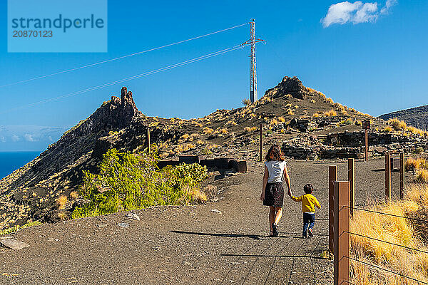 A mother and her son walking along the rock formation on the coast of Agaete  Roque Guayedra  Gran Canaria