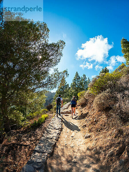 A couple of hikers on the trail up to Roque Nublo in Gran Canaria  Canary Islands. vertical photo