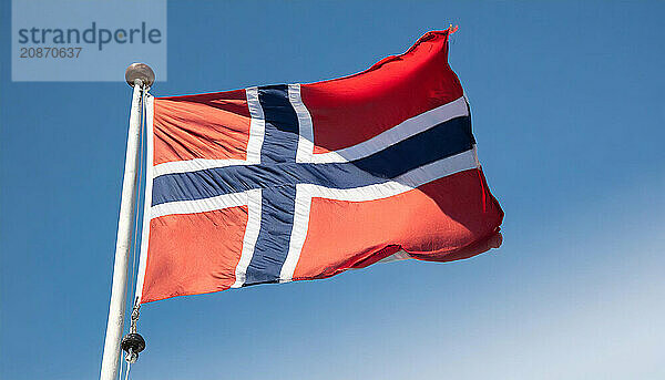 The flag of Norway flutters in the wind  isolated against a blue sky