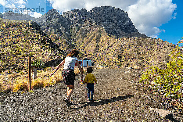 A mother and her son walking and having fun in the mountains of the Agaete coast  Roque Guayedra  Gran Canaria