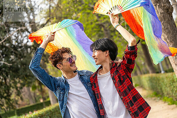 A multi-ethnic gay couple celebrating diversity and love in a park