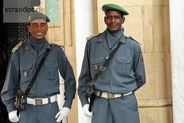 Guards at the Royal Palace in Rabat  Morocco  Two smiling security guards pose in uniform in front of a traditional backdrop  Rabat  North Africa  Africa