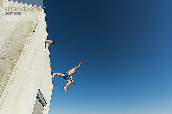 Man jumping from concrete construction  Tjuvholmen  Aker Brygge  Oslo  Norway  Europe