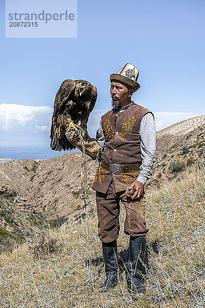 Traditional Kyrgyz eagle hunter with eagle in the mountains  hunting  near Bokonbayevo  Issyk Kul region  Kyrgyzstan  Asia