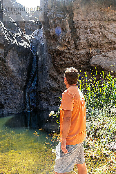 A man looking at the waterfall at Charco Azul in El Podemos a Agaete on Gran Canaria  Canary Islands