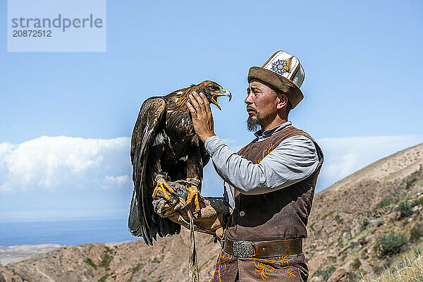 Traditional Kyrgyz eagle hunter with eagle in the mountains  hunting  near Bokonbayevo  Issyk Kul region  Kyrgyzstan  Asia