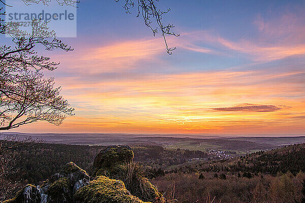 Panorama of a romantic landscape at sunset in the evening light. beautiful spring landscape in the mountains. Lawn and rolling hills. View from a cliff to the horizon. The Great Peak  Hesse  Germany  Europe