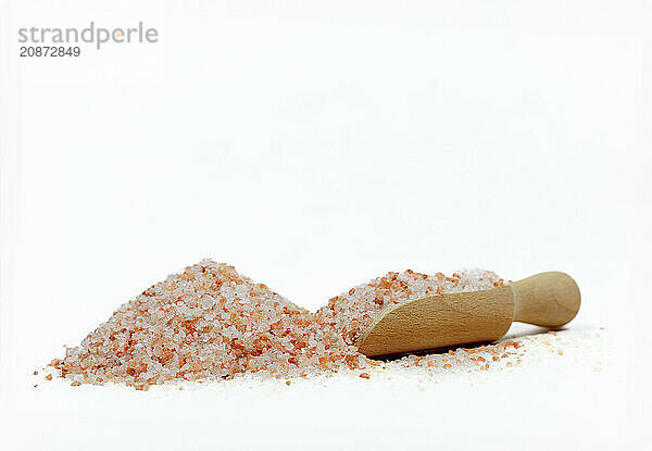 Wooden spoon with pink himalayan salt isolated on white background and copy space