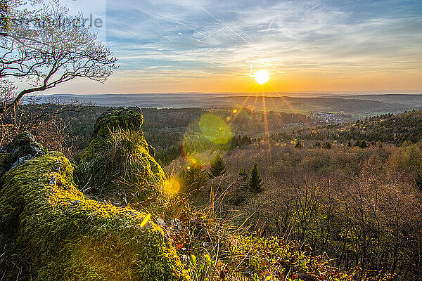 Panorama of a romantic landscape at sunset in the evening light. beautiful spring landscape in the mountains. Lawn and rolling hills. View from a cliff to the horizon. The Great Peak  Hesse  Germany  Europe