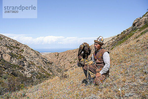 Traditional Kyrgyz eagle hunter with eagle in the mountains  hunting  near Bokonbayevo  Issyk Kul region  Kyrgyzstan  Asia