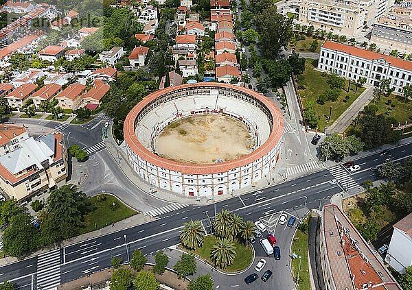 Aerial view of a historic bullring with red roofs  embedded in a town  surrounded by streets  houses and green areas  aerial view  bullring  Cáceres  Caceres  Caçris  Extremadura  Spain  Europe