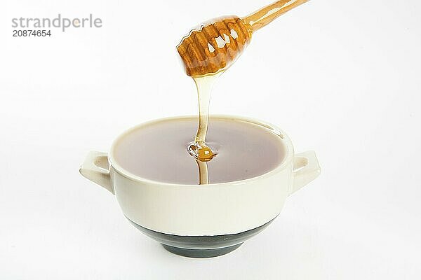 Juicy honey in a cup and spoon on white background