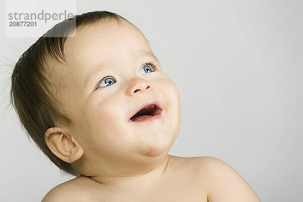 The blue-eyed baby  close up. gray background