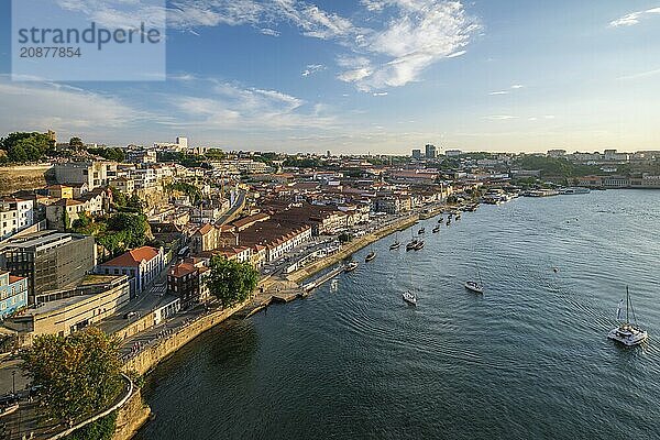 View of Vila Nova de Gaia city and Douro river with tourist boats on sunset. Porto  Portugal  Europe