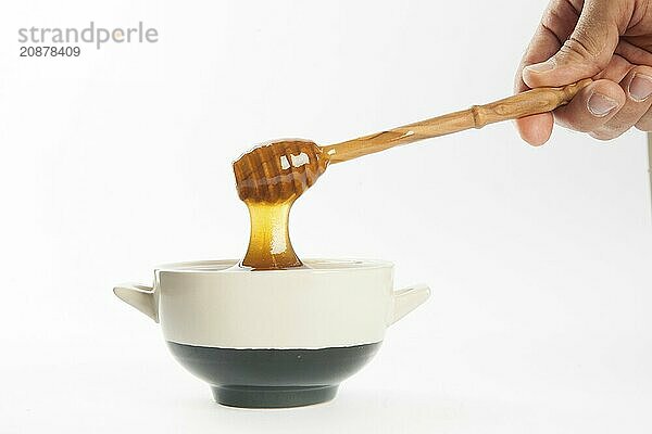 Juicy honey in a cup and spoon on white background