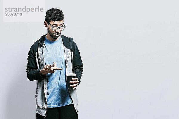 Person holding and pointing coffee on isolated background. Guy pointing disposable cup of coffee isolated