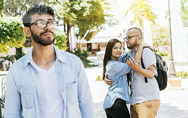 Distracted girlfriend looking at another man on the street. Unfaithful girlfriend looking at another man on the street  Unfaithful girl looking at another man on street and her boyfriend claims her