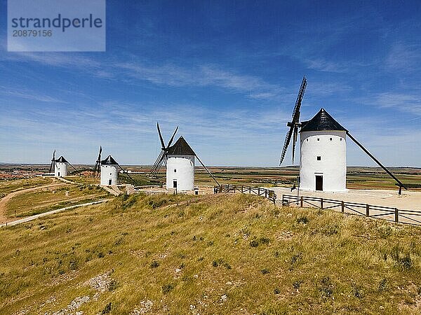 Several white windmills with black roofs in a vast scenic landscape under a clear blue sky  aerial view  Alcazar de San Juan  Ciudad Real  Castilla-La Mancha  Route of Don Quixote  Spain  Europe