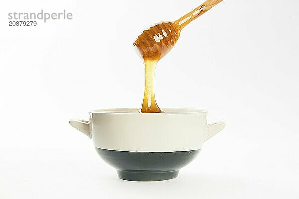 Juicy honey in a cup and spoon on white background