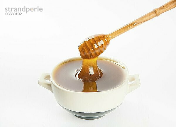 Juicy honey in a cup and spoon on white background