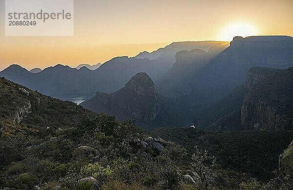 Light mood at sunrise at the Blyde River Canyon  sun rises behind a mountain peak  canyon landscape with sunbeams against the light  view of canyon with Three Rondawels peak and Table Mountains  Panorama Route  Mpumalanga  South Africa  Africa