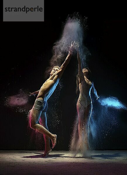 Young man and woman holding hands and looking up in cloud of pink and blue dust studio shot