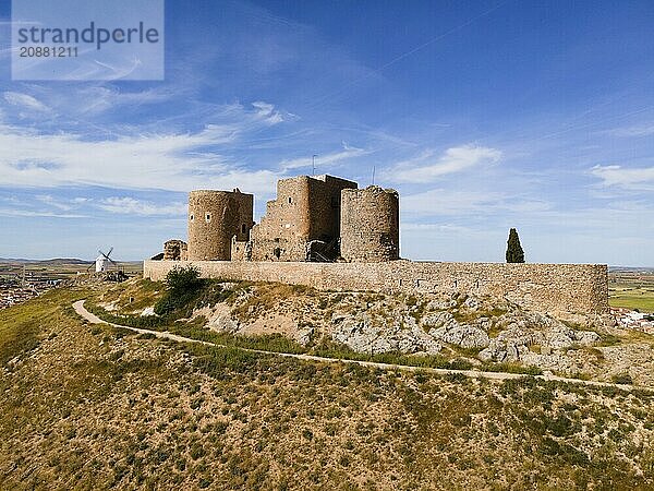 A medieval castle on a hill with stone walls and a path  blue sky in the background  aerial view  Consuegra  Toledo  Castilla-La Mancha  Spain  Europe